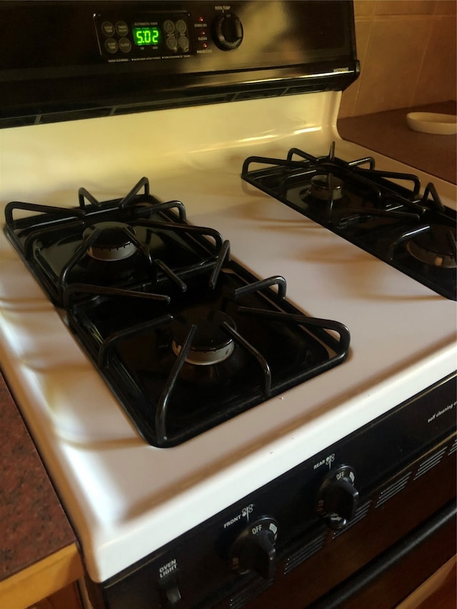 room details featuring backsplash and range with gas cooktop