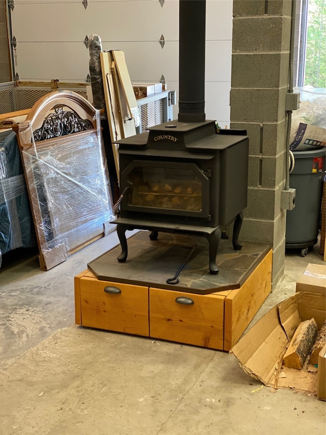 details featuring a wood stove and concrete flooring