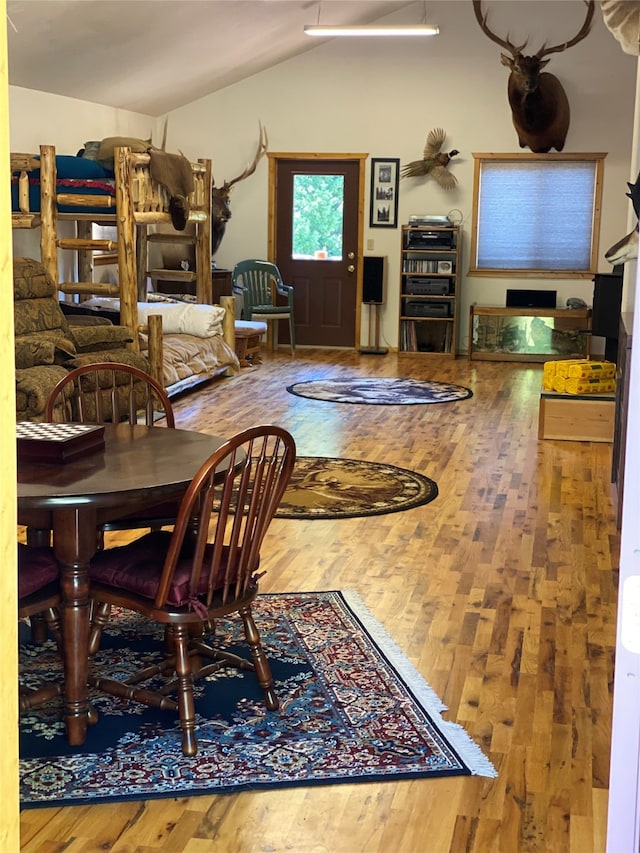 dining space with vaulted ceiling and hardwood / wood-style floors