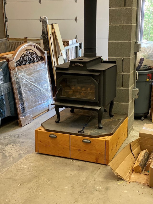 interior details featuring a wood stove and concrete flooring