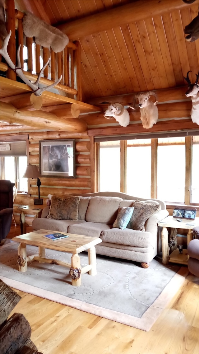 living room with lofted ceiling with beams, wooden ceiling, hardwood / wood-style flooring, and rustic walls