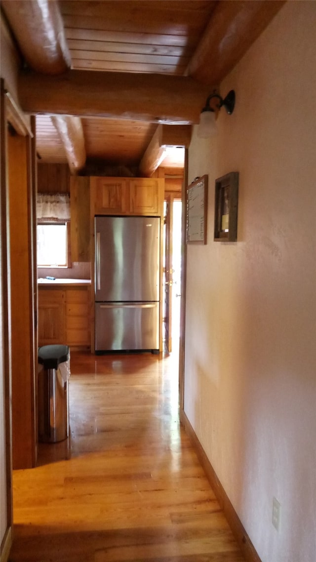 hallway featuring wooden ceiling, light hardwood / wood-style flooring, and beam ceiling