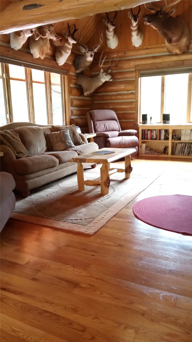 interior space with hardwood / wood-style flooring, a healthy amount of sunlight, and rustic walls