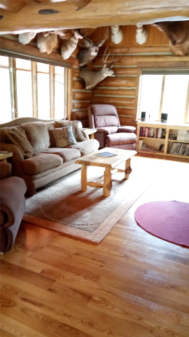 living room featuring wood-type flooring and rustic walls