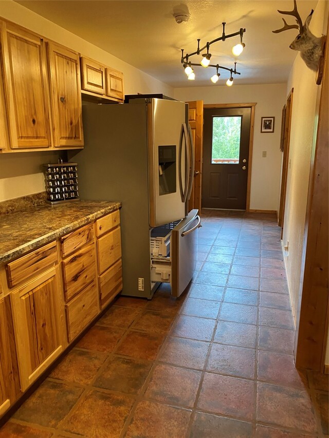 kitchen featuring stainless steel fridge with ice dispenser, track lighting, and dark tile patterned flooring