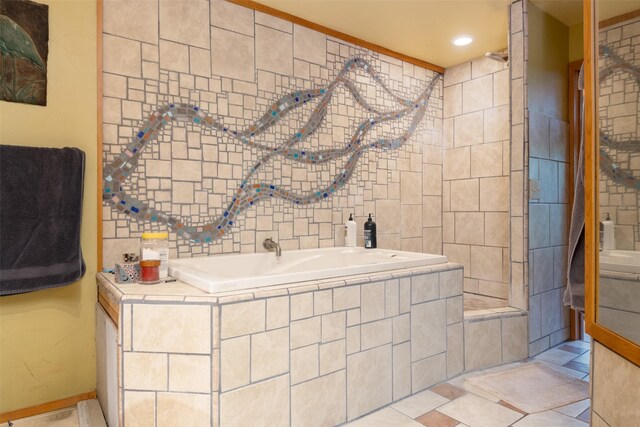 bathroom with tile patterned flooring and tiled bath