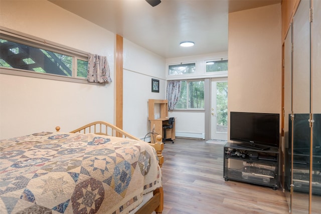 bedroom featuring hardwood / wood-style floors, ceiling fan, and baseboard heating