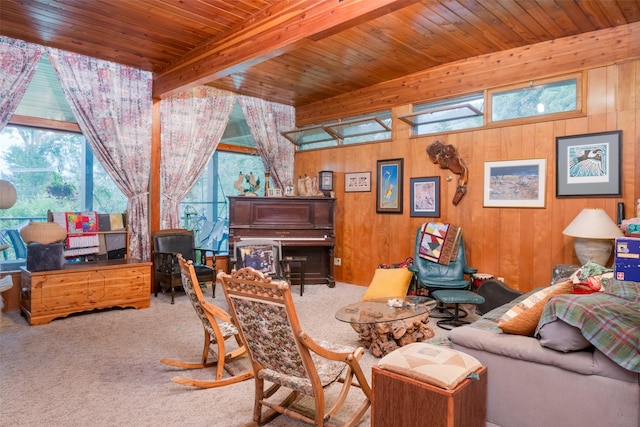 carpeted living room with beamed ceiling, wood ceiling, and wooden walls