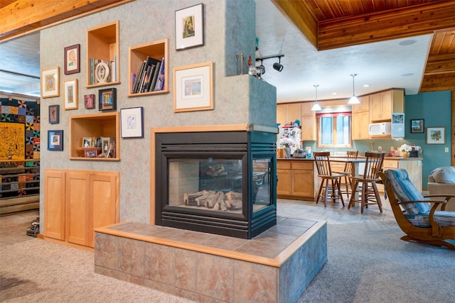 living room with a multi sided fireplace, light colored carpet, and wood ceiling