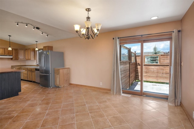 kitchen featuring hanging light fixtures, an inviting chandelier, lofted ceiling, light tile patterned floors, and appliances with stainless steel finishes