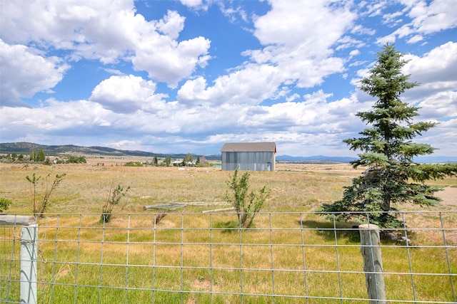 view of yard with a mountain view and a rural view