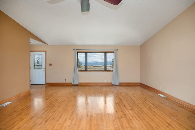 spare room featuring lofted ceiling and light wood-type flooring