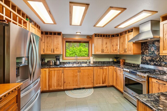 kitchen featuring light tile patterned floors, stainless steel appliances, wall chimney exhaust hood, and sink