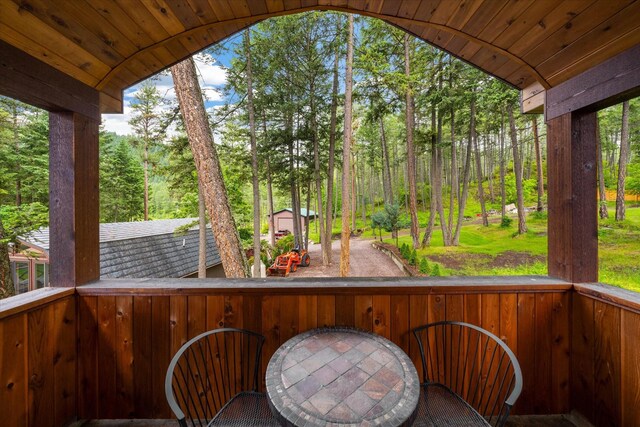 sunroom featuring vaulted ceiling and wood ceiling