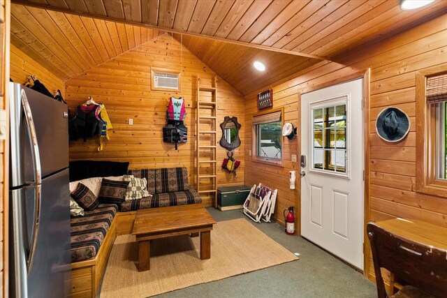 carpeted living room with wood ceiling, wooden walls, and lofted ceiling