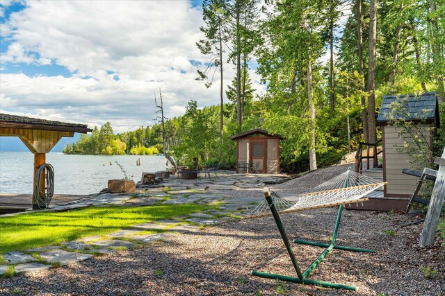 view of yard with a storage shed and a water view