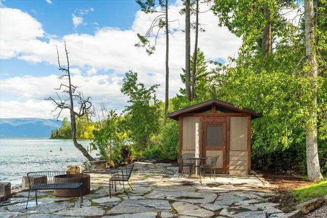 view of patio with a storage unit and a water and mountain view