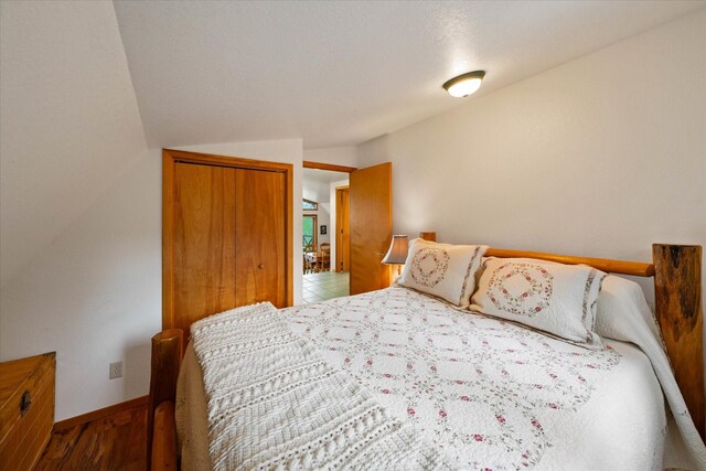 bedroom featuring tile patterned flooring, lofted ceiling, and a closet