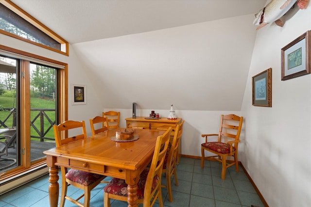 tiled dining area with a baseboard radiator and lofted ceiling