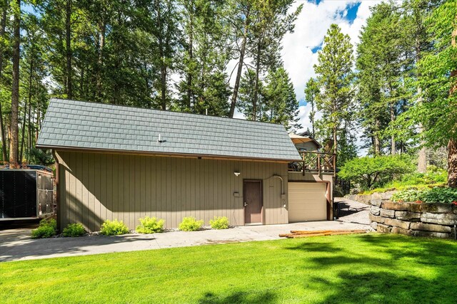 exterior space with a garage and a lawn