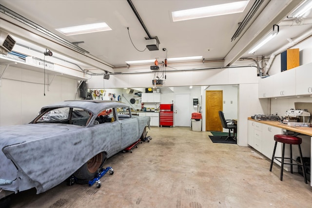 garage with a workshop area and a garage door opener