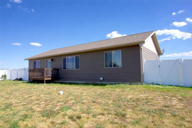 back of house with a lawn and a wooden deck