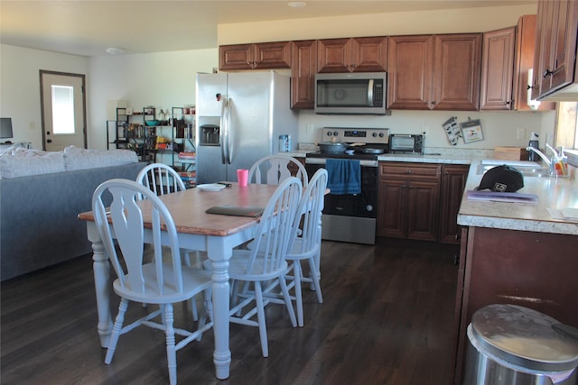 kitchen featuring appliances with stainless steel finishes, dark hardwood / wood-style flooring, and sink