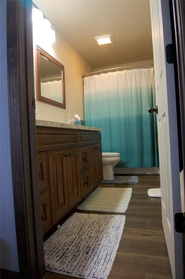 bathroom with hardwood / wood-style floors, vanity, toilet, and a shower with curtain