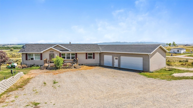 ranch-style house featuring roof with shingles, driveway, and an attached garage