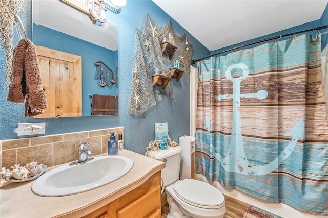 bathroom featuring tasteful backsplash, curtained shower, vanity, and toilet