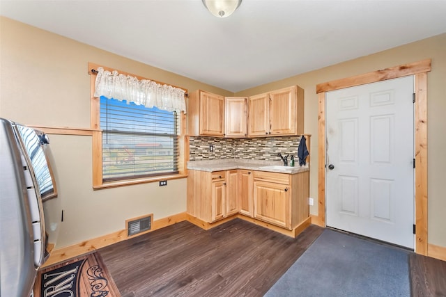 kitchen with light countertops, visible vents, decorative backsplash, light brown cabinets, and a sink