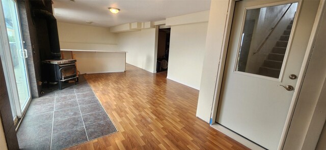 unfurnished living room with wood-type flooring and a wood stove