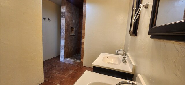 bathroom featuring a tile shower, tile patterned flooring, and vanity