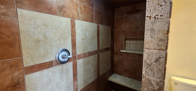 bathroom with a tile shower and toilet