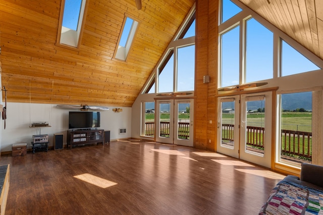 unfurnished living room with a skylight, high vaulted ceiling, a healthy amount of sunlight, and wood ceiling