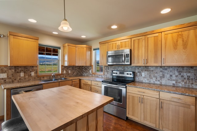 kitchen with sink, a center island, wood counters, dark hardwood / wood-style floors, and appliances with stainless steel finishes