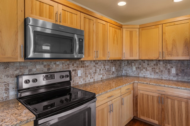 kitchen featuring light stone countertops, decorative backsplash, and stainless steel appliances