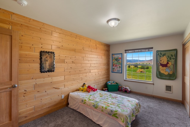 bedroom with wood walls and carpet