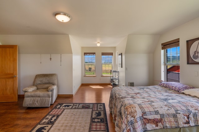 bedroom with vaulted ceiling and dark hardwood / wood-style floors