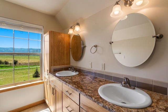 bathroom featuring a mountain view, tile patterned floors, vanity, and vaulted ceiling