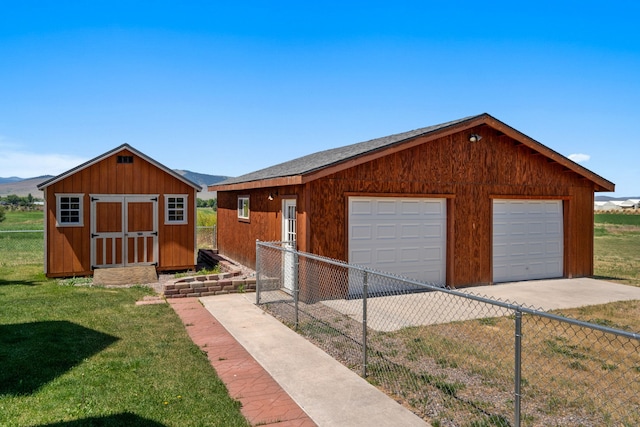 view of front of home with a garage, a shed, and a front yard