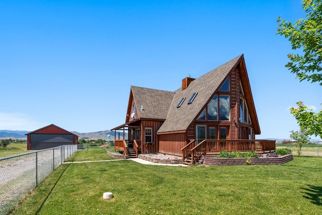 rear view of house with a mountain view and a lawn