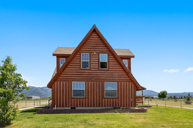 view of property exterior featuring a lawn, a mountain view, and a rural view