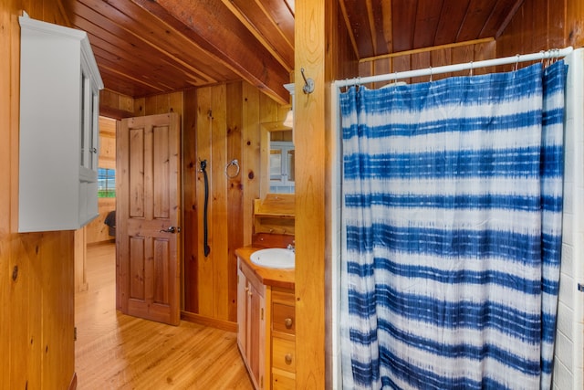 bathroom with vanity, wood walls, walk in shower, wood-type flooring, and wood ceiling