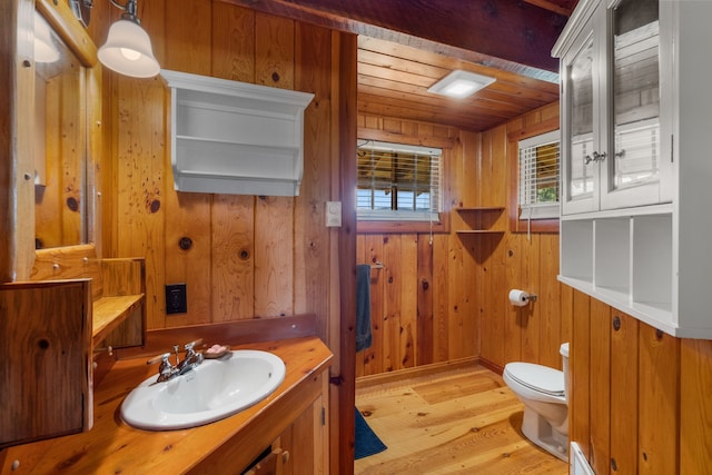 bathroom featuring hardwood / wood-style floors, vanity, wood walls, toilet, and wood ceiling