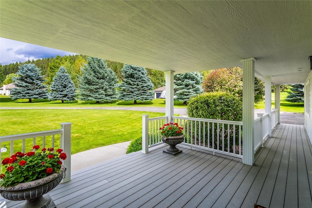 wooden deck featuring a porch and a lawn