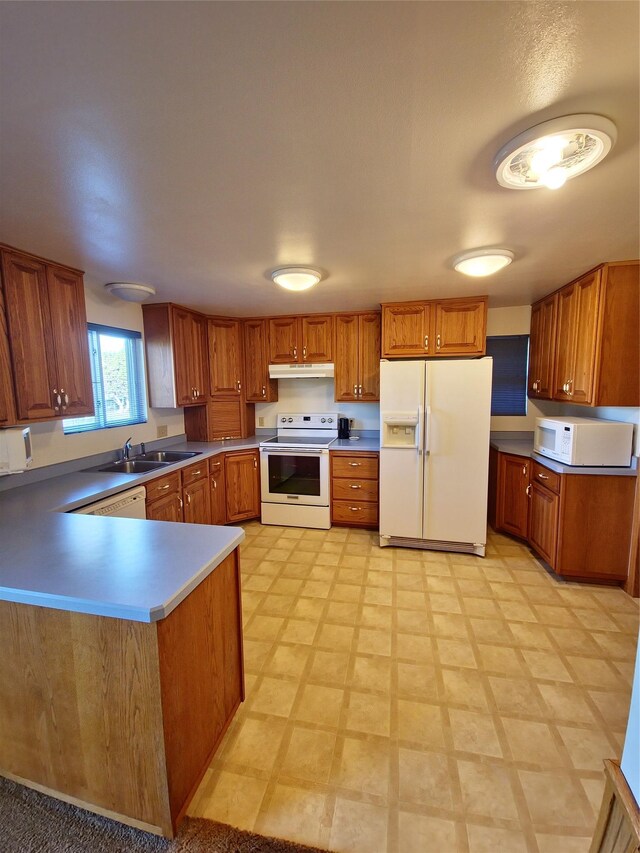 512 S Oak St, Townsend, MT 59644 - kitchen featuring brown cabinetry, a sink, under cabinet range hood, and white appliances