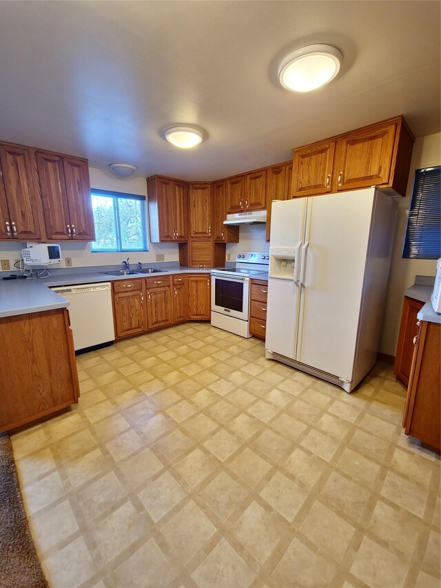 512 S Oak St, Townsend, MT 59644 - kitchen with a sink, brown cabinets, white appliances, light floors, and under cabinet range hood