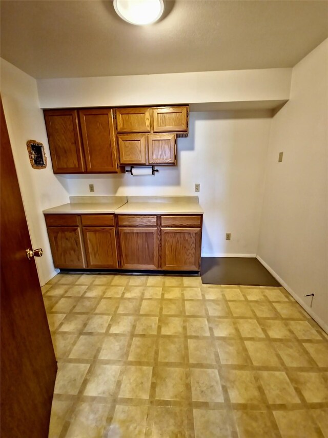 512 S Oak St, Townsend, MT 59644 - kitchen with light floors, brown cabinetry, baseboards, and light countertops