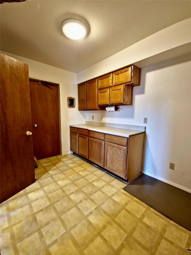 512 S Oak St, Townsend, MT 59644 - kitchen with light floors, brown cabinets, baseboards, and light countertops